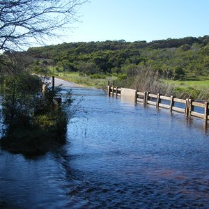 Die ou laagwaterbruggie (bo) oor die Uilkraalrivier onderkant die Kraaiboschdam se uitloop op die Gansbaai / Bredasdorppad, via Baardskeerdersbos en Elim, wat gedurende die groot reëns in Oktober/Desember 2013 vir die laaste keer oorstroom is, is onlangs met ‘n “Boere Brugpartytjie” gegroet en die nuwe brug (onder) is verwelkom. Die nuwe brug is reeds vir verkeer oopgestel en die pad kan gedurende die Feestyd tot by die Napier-afdraai gebruik word.